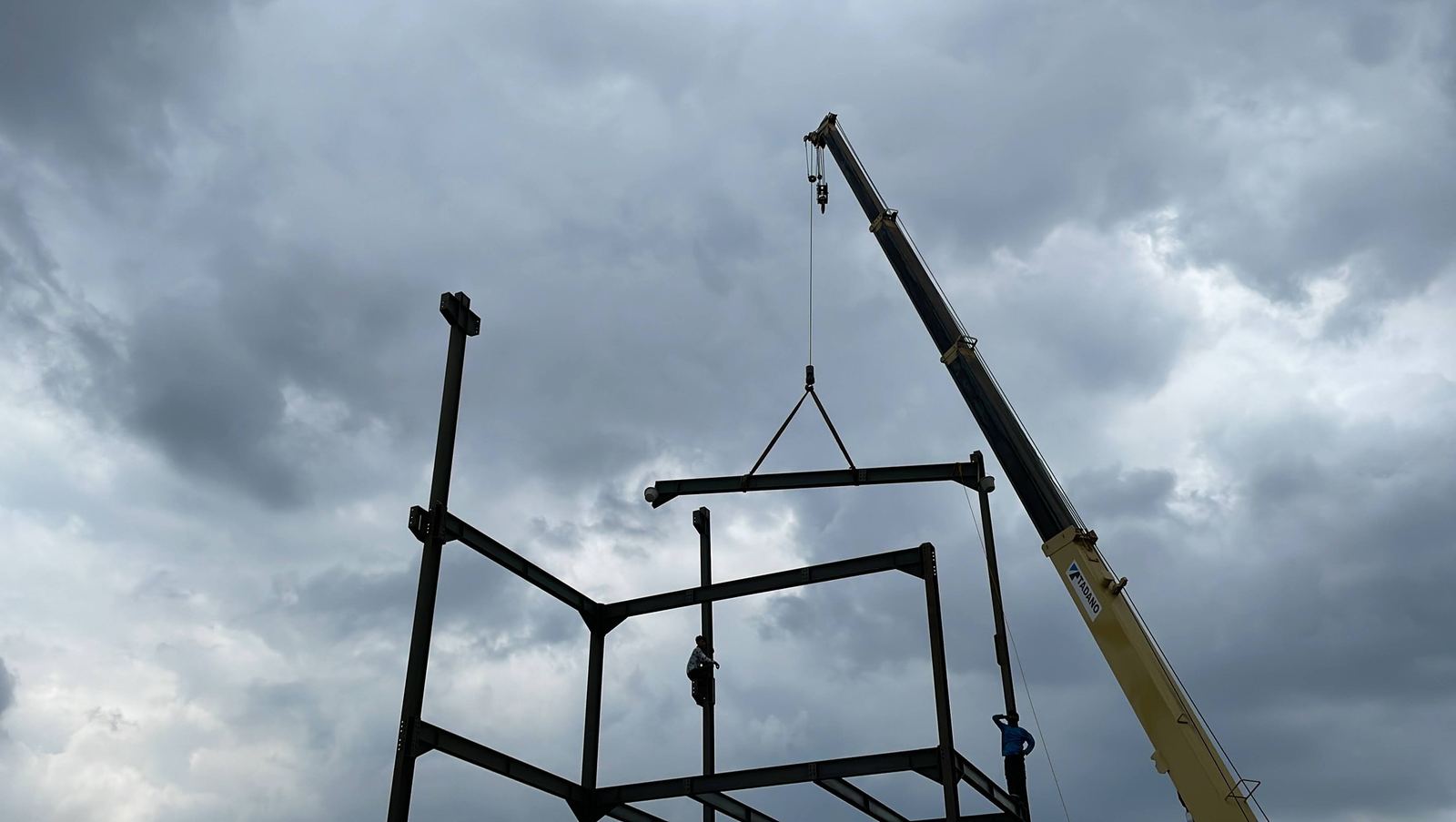Rangka baja diangkat dengan crane di lokasi proyek